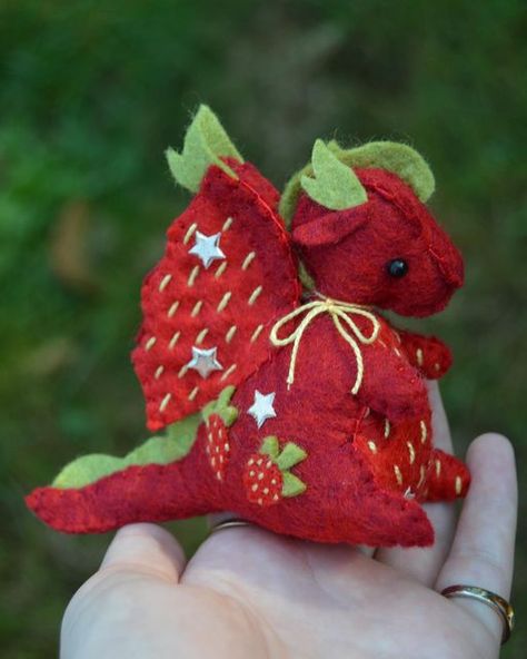 Daisy on Instagram: "I’ve been working on the auction commission for a couple days! The amazing commissioner gave me a prompt of “strawberries and stars” and I think it turned out absolutely adorable! - Dragon pattern by robynabobbin! 💕 - #handmade #homemade #diy #sewing #felt #feltart #fiber #fiberart #plush #plushie #halloween #spooky #dinosaur #pumpkin #scary" Spooky Dinosaur, Dinosaur Pumpkin, Sewing Felt, Plushies Diy, Felt Dragon, Pumpkin Scary, Cute Sewing Projects, Handmade Plushies, Plushie Patterns