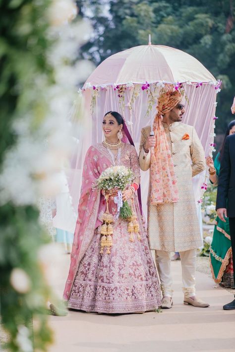 She looked beautiful in her exquisite onion pink lehenga. #bride #indianbride #bridallehenga #weddinglehenga #pink #bridalentry #weddingentry #indianweddingentry #kaleera #indianjewellery #indianlehenga #shaadisaga #bridalinspo #bridalinspiration Bridal Umbrella, Monsoon Wedding, Wedding Jitters, Floral Umbrellas, Bride Entry, Delhi Wedding, Indian Wedding Photography Poses, Bridal Poses, Wedding Couple Poses