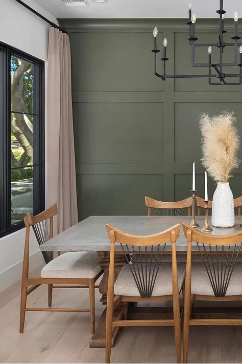 This sophisticated dining room elevates entertaining with a stunning green wood accent wall.  The rich wood tones of the table and chairs complement the natural element, creating a warm and inviting atmosphere. Perfect for hosting memorable meals with a touch of modern flair. #diningroom #diningroomset #elegantdining #furniture #interiordesign #homedecor #classicdesign #timelessstyle #entertaining #dinnerparty #familymeals #greenaccentwall #greendecor #woodaccents #naturalliving #biophilicdesign Dark Green Dining Room Accent Wall, Two Tone Wall Dining Room, Green Wood Accent Wall, Green Wall Dining Room, Green Accent Wall Dining Room, Green Dining Room Paint, Dark Green Dining Room, Green Dining Room Walls, Beautiful Dining Room Decor