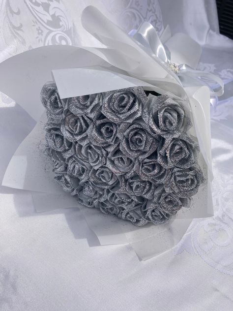 Introducing our DIAMOND bouquet! Beautiful handmade satin rose bouquet with sparkly, silver glitter. Great for anniversaries, birthdays, holidays, weddings, graduations or simply to show someone you're thinking of them. This bouquet has a lean and long luxurious look due to the slim stem.  Message us for custom requests. Dimensions are included in pictures, but depend on bouquet size/number of roses. The pictured bouquet has 25 roses. Please don't hesitate to message us with questions! Flat Bouquet Flowers, Glitter Flower Bouquet, Large Rose Bouquet, Silver Flower Bouquet, Satin Rose Bouquet, Diamond Bouquet, Paper Rose Craft, Satin Bouquet, Silver Bouquet