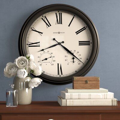 This inviting metal wall clock is deep and features rub through on the edges. Designed to be used indoors or outdoors and includes a glass cover and rubber seals to protect the inside of the clock from inclement weather. The dial is highlighted by easy-to-read Roman numerals, a thermometer for temperature, a hygrometer for humidity, and an hour and minute hand. | Howard Miller® Aspen 22" Wall Clock Glass / Metal in Black, Size 22.0 H x 22.0 W x 3.25 D in | Wayfair Gallery Wall Clock, Wall Clock Classic, Water Candle, Howard Miller, Retro Wall Clock, Wood Backdrop, Mid Century Modern Walls, Antique Clocks, Hygrometer