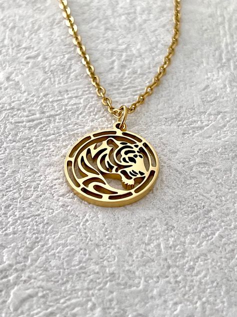 Celebrate the special day of someone you cherish with our Zodiac Pendant Necklace, a gift that aligns the stars in their honor. Available in radiant gold, lustrous silver, and enchanting rose gold, this necklace is more than an accessory; it's a personal talisman. Expertly crafted from premium stainless steel and finished with a generous 18K gold plating, our necklaces utilize a state-of-the-art intracranial vacuum plating technique to ensure a waterproof and fade-resistant shine. Wear your zodi Tiger Zodiac, Tiger Necklace, Plating Techniques, Tiger Pendant, Zodiac Pendant Necklace, Zodiac Necklace, Zodiac Pendant, Personalized Pendant, Zodiac Necklaces