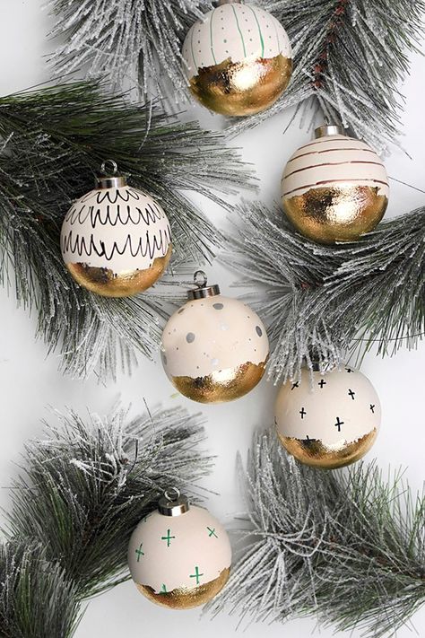 Learn how to take simple ceramic Christmas balls and transform them into gorgeous statement Gold Leaf Christmas Ornaments!  The gold foil will shimmer and shine on your tree. Delineate Your Dwelling #goldleafornaments #goldfoilornaments #DIYchristmasornaments