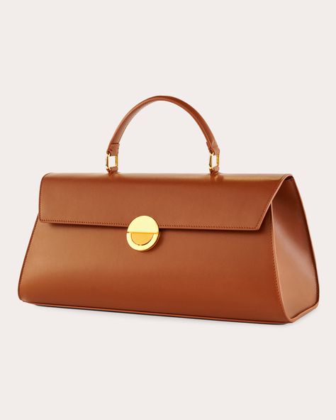 Inspired by activist and artist Josephine Baker, this top-handle bag exudes minimalist elegance with its horizontal orientation, polished goldtone hardware and calfskin leather construction. The flap opening is fastened with Objets Daso's signature push-lock closure to keep items stored safely in the pocketed interior. Includes removable shoulder strap Signature push-lock closure Top handle Goldtone hardware Interior pocket Outer: 100% calfskin leather Lining: 100% lambskin leather Store in dust bag Made in Italy Measurements Width: 14.56in Height: 6.29in Depth: 5.11in | Objets Daso Women's Josephine Handbag in Tan | Leather Josephine Baker, Leather Store, Tan Handbags, Stylish Purse, Elegant Bags, Handbag Heaven, Pretty Bags, Girls Bags, Hand Bags