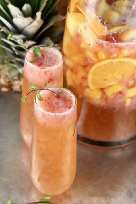 Champagne Punch is the perfect party cocktail for New Year's Eve and celebrations all year long! A delicious combination of sparkling wine, pineapple, strawberry and orange flavors is refreshing and delicious. A great make ahead large batch cocktail. Punch With Champagne Recipes, Wine And Champagne Drinks, Champagne Party Drinks, Cocktail Recipes With Champagne, New Years Eve Large Batch Cocktails, Alcoholic Drinks For A Party Large, Champagne Drinks Recipes, Drinks With Champagne, Champagne Recipes