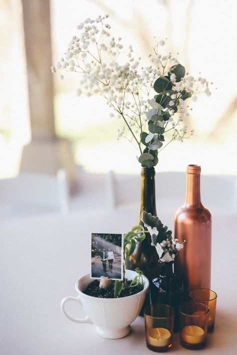 Wine Bottle Centerpieces Eucalyptus, Vintage Bottle Centerpieces, Wine Bottle With Flowers Centerpieces, Wine Bottle Flower Arrangements Wedding, Wine Bottle Table Decor, Picture Centerpiece Ideas, Wine Bottle Flower Arrangements, Wine Bottle Centerpieces For Wedding, Wine Centerpieces