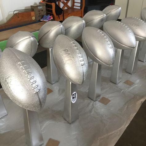 My centerpieces are done for the Woodridge Football Fundraiser!  Dollar Tree bud vases filled with sand, cement glued to foam football (with a little carving out) and spray painted silver. Great Vince Lombardi replica for $2 each! Planning Sport, Superbowl Ideas, Football Centerpieces, Sports Party Centerpieces, Football Fundraiser, Football Banquet, Football Baby Shower, Football Ideas, Shower Prizes