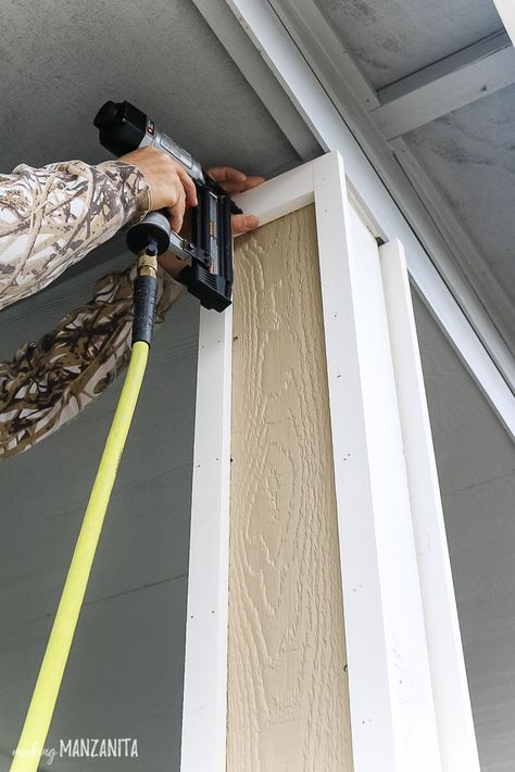 Nailing pre-primed trim pieces to porch posts for added curb appeal! Learn how to give your boring porch columns an easy DIY farmhouse makeover! #frontporch #porch #porchideas #DIY Front Porch Posts, Porch Pillars, Front Porch Columns, Farmhouse Makeover, Add Curb Appeal, Column Covers, Porch Remodel, Building A Porch, Porch Columns