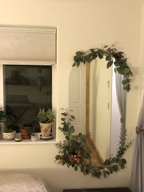 Raw round mirror framed with floral arrangements and greenery. Balcony Mirror Ideas, Plant Covered Mirror, Leaves Around Mirror, Round Mirror Bedroom Aesthetic, Fake Flowers Around Mirror, Decorating My Mirror, Decoration Around Mirror, Mirror Arrangement Ideas, Mirror Decorating Ideas Aesthetic