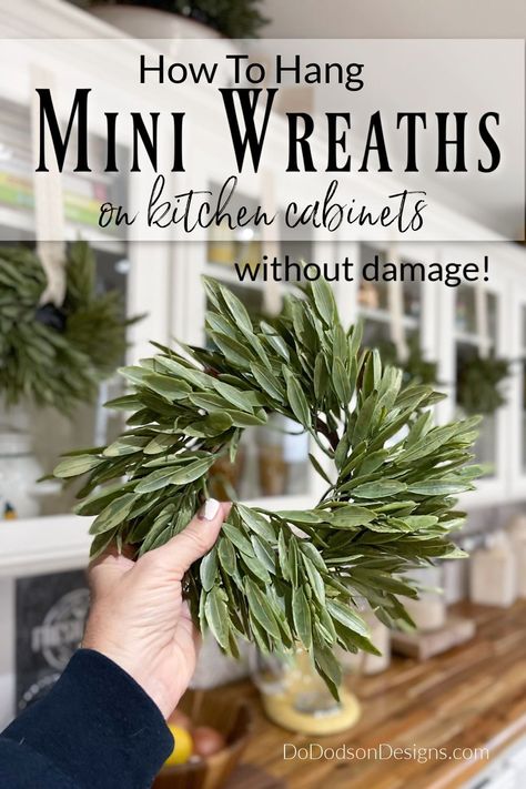 It's time to decorate for Christmas! Want to add a little holiday flair to your kitchen cabinets? Learn how to hang mini wreaths quickly and easily without damaging your cabinets. My farmhouse never looked more charming. Mini Wreaths On Kitchen Cabinets, Wreaths On Windows Indoors, Window Wreaths Indoor, Wreath In Kitchen, Kitchen Window Wreath, Kitchen Wreath Ideas, Wreaths On Kitchen Cabinets, Christmas Kitchen Decor Ideas, Wreath Kitchen