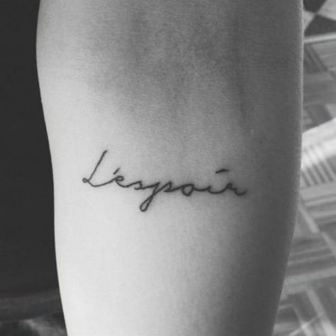 20 One-Word Tattoo Ideas For The Minimalistic Woman Tattoo Ideas In French, L'espoir Tattoo, Espoir Tattoo, French Tattoos For Women, One Word Tattoo Ideas, French Word Tattoos, French Tattoo Quotes, Word Tattoo Placements, Latin Tattoo