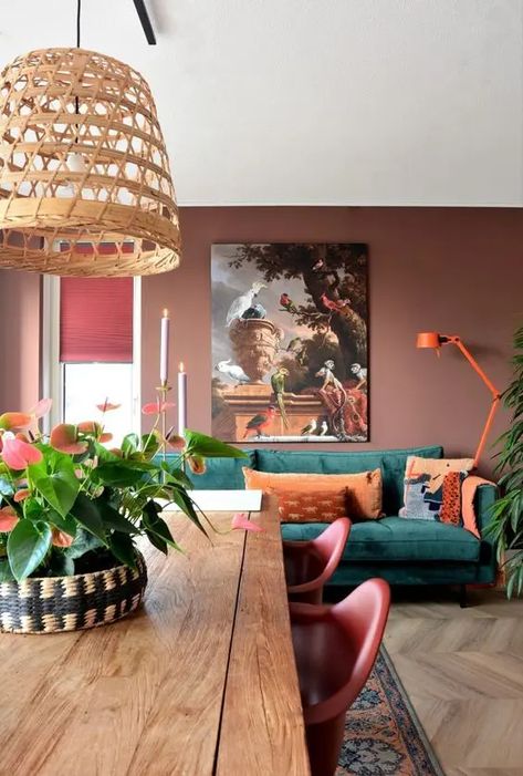 a beautiful muted colored living room with chocolate brown walls, a green sofa with orange pillows and a lamp, an artwork and a dining zone Små Rum Lidt Plads, Art Deco Style Interior, Green Sofa, Brown Walls, Brown Living Room, Eclectic Interior, Home Lifestyle, A Living Room, Room Colors