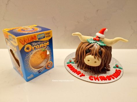 The picture shows a Terry's Chocolate Orange in it's box and the edible Highland Cow that I made it into with a festive Santa Hat and holly for decoration. Easy Highland Cow Cake, Highland Cow Tutorial, Highland Cow Cake, Orange Characters, Cow Cake, Cow Cakes, Terry's Chocolate Orange, Christmas Figures, Christmas Cakes