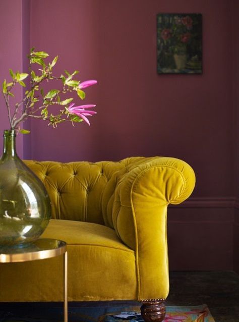 Deep mustard hues and dark shades of red like berry are on trend this season when it comes to decorating. Wall Color Schemes, Yellow Couch, Velvet Couch, Purple Walls, Beautiful Sofas, غرفة ملابس, Pink Walls, A Living Room, Colour Schemes