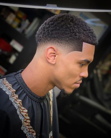 Bring out the natural texture of your curls with a cropped top and mid taper fade. This hair style not only embraces the unique texture of curly hair but also showcases a youthful vibe, making it a popular and fashionable option for black boys seeking a modern and personalized haircut. Black Man Bun With Fade, Black Fades Men, Black Male Hairstyles Fade, Men’s Haircut Taper Fade, Black Hair Cuts Men Taper, Black Man Faded Haircut, Taper Fade Haircut Black Short Hair, Ninja Low Taper Fade, Taper Fade With Short Hair