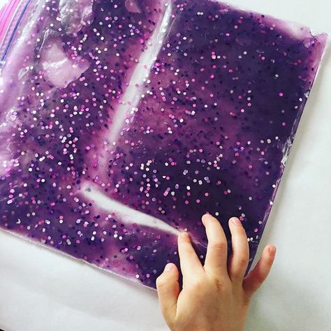 It’s been a week full of sensory fun over here! Our little nugget loves practicing her letters and playing with this squishy, glittery, purple sensory bag! We saw this idea over on @cintaandco a little while ago and just had to make one for ourselves! To make your own...mix hair gel, food coloring, and glitter in a small bowl. Transfer to a storage-size Ziploc bag. Squeeze out any air and seal the bag. We taped over the sealed end as an added precaution. 😉 #sensorybag #practicingletters #sensor Purple Sensory Activities, Ziploc Sensory Bags, Homemade Sensory Bags, Purple Sensory Bin, Sensory Crafts For Preschoolers, Sensory Mats Diy, Ziplock Bag Sensory Activities, Sensory Pouches, Galaxy Sensory Bottle