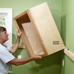 It's easier to hang the uppers when you're not hanging way over the base cabinets. Rest the uppers on a ledger board—it'll ensure a nice, straight alignment and eliminate the frustration of holding the cabinets in place while screwing them to the wall. Cabinets In Bathroom, How To Install Kitchen Island, Kitchen Cabinet Installation, Install Cabinets, Woodworking Kitchen Cabinets, Island Cabinets, Installing Kitchen Cabinets, Traditional Kitchen Cabinets, Cabinet Installation