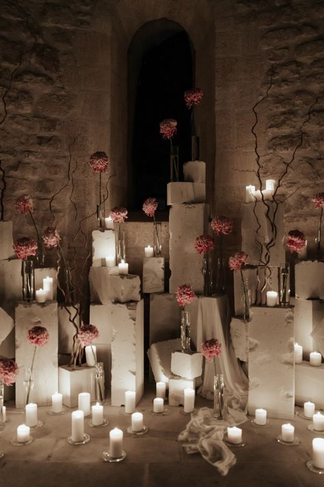 Elodie Villemus used 450 candles to create the perfect contrast against the ancient stones of the chapel. This also helped create the perfect ceremony space featuring white votives surrounding concrete blocks adorned with single stem vases. Pink was the perfect floral color choice to help create a pop of soft color against the stones. Candle Wedding Ceremony Altars, Candle Entrance, Negative Space Wedding, Candle Installation, Rose Ceremony, Aisle Candles, Stone Structures, Ceremony Candles, London Apartment