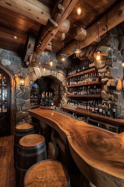 A rustic wine cellar bar featuring stone archways, a polished wooden countertop, and barrel-style stools. The walls are lined with shelves full of wine bottles, creating a cozy, inviting atmosphere for wine lovers. Rustic Bars For Home, Wood Bar Countertops, Wine Cellar Design Rustic, Wine Barrel Bar Ideas, Wine Bar Ideas, Rustic Wine Cellar, Sedona House, Rustic Home Ideas, Cabin Update