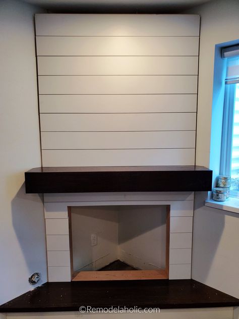 This corner fireplace is a great build to add style and extra warmth to any corner of the house. The electric fireplace insert makes the install so easy and is much less expensive than adding a gas fireplace, and the shiplap fireplace surround and hidden storage mantel hide all the cords for the TV above the fireplace. Get the full woodworking plans and tutorial at Remodelaholic.com Build A Corner Fireplace, Diy Corner Fireplace, Glam Fireplace, Corner Fireplace Makeover, Floating Mantle, Corner Electric Fireplace, Fireplace Frame, Rustic Office, Shiplap Fireplace