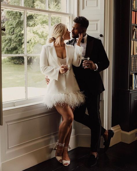 Trying to find the perfect evening look for your modern spring wedding? Follow this bride's lead and wear a gorgeous mini feathered trim dress and an all-white blazer that looks stunning with the groom's classic black tux. Find more gorgeous feather wedding dresses for every bridal occasion at the link. // Photo: Emma Wilkinson Photography Open Back Short Wedding Dress, Chic Wedding Reception Dress, Parisian Short Wedding Dress, Old Hollywood Wedding Dress Short, Winter Wedding Short Dress, Short Wedding Gowns The Bride, Winter Short Wedding Dress, Tulle Short Wedding Dress, Winter Wedding Dress Short