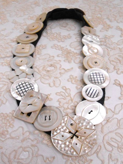 Listed here is another one of my vintage and antique mother of pearl buttons necklaces.  It is number 88!  I have used creamy white pearl/shell buttons.  The necklace measures approximately 24 inches long and has 28 buttons and one buckle.   I make these using a man's silk tie where I cut and finish one end and sew on a large snap.  Each button is individually sewn on.  Although the buttons can be heavy the necklace lays nicely on anyone who has tried one on.  You can wear it comfortably all day.  I have. Thanks for looking and please don't hesitate to contact me if you have any questions.  Thanks for stopping by my Etsy shop! Old Watches Crafts Ideas, Fabric Jewelry Handmade, Button Choker, Craft Bouquet, Vintage Buttons Crafts, Button Wreath, Buttons Crafts, Button Diy, Button Ideas