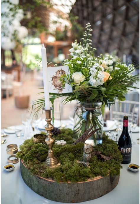 a woodland wedding centerpiece of a wood slice, moss, blooms and greenery in a jar, feathers and candles Boho Chic Forest Wedding, Woodland Fairy Wedding Table Decor, Woodland Theme Centerpieces Decor, Moss Decorations Wedding, Moss Table Wedding, Moss Table Centerpiece, Woodland Table Centerpieces, Enchanted Woodland Wedding, Enchanted Forest Wedding Table