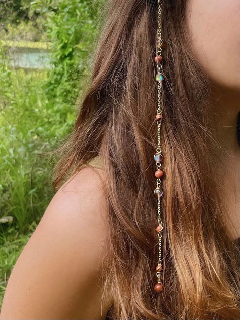 Mars Goddess Hippie Hair Bead: Set with the intention of providing protection and grounding. Perfect for protection during mercury retrograde! Includes a Sensitive Scalp Attachment Clip to attach the Hippie Hair Bead to your hair! Crystals: Glass Shiny Brown Beads and Gold Stone. 🫧Every order comes with a goodie bag full of an assortment of hippie items!🫧 Hippie Hair Beads are made using Sterling Silver Wire/Gold Plated Wire each piece is made with ethnically sourced crystals<3 Each are handma Boho Hair Jewelry, Crystals On Hair, Hippie Hair Jewelry, Hair Crystal Accessories, Cottage Core Hair Accessories, Wire Wrapped Hair Accessories, Hair With Charms, Fairy Hippie Outfits, Hair Jewlrey