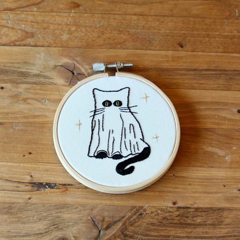 This Sweet Little Ghost Kitty Is Hand Stitched With Dmc Thread On Cotton Fabric And Adorned With 3 Stars Stitched With Dmc Gold Metallic Thread. It Is Framed In A 4 Inch Wooden Hoop. Perfect For Spooky Season Or For All Year Round! This Piece Is Ready To Ship! Check Out My Etsy: Http://Www.Etsy.Com/Shop/Bizzybeeembroidery Or Follow Me On Instagram For More Photos! @Bizzybee.Embroidery Horror Movie Embroidery, Undertale Embroidery, Halloween Embroidery Ideas, Witchcraft Embroidery, Embroidery Frame Ideas, Embroidery Cat Patterns, Groovy Embroidery, Mini Embroidery Patterns, Creepy Embroidery