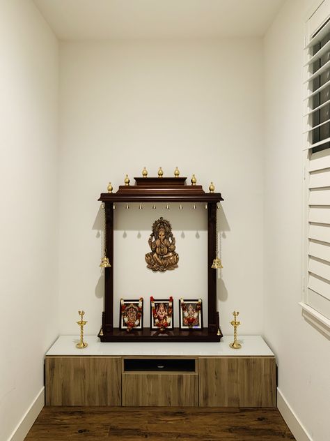 Open style mandir. Bottom drawer is from ikea besta. Top gopuram is assembled from floating shelves purchased from lowes(allen-roth). Vertical columns are made out of crown molded wood and stained with Varathane(cognac color) wood stain from Home depot. Crowns are also from lowes spray painted with metallic gold (rustoleum) from Home depot. Try this yourself. Gopuram Designs For Pooja Room, Open Mandir In Living Room, Open Pooja Room, Floating Pooja Unit, Diy Puja Mandir Home, Ikea Besta Top, Floating Shelves Mandir, Color Wood Stain, Pooja Cabinet