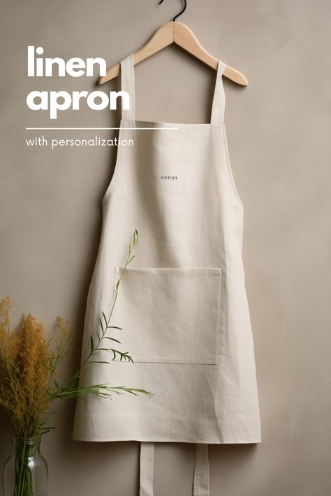 A minimalist linen apron is the perfect addition to any kitchen. It offers a clean and simple design that is both functional and stylish. Made from high-quality linen, this apron is lightweight and breathable, making it comfortable to wear for long periods of time. The neutral color and minimalistic design make it a versatile piece that can be worn by both men and women. Whether you're cooking up a storm or hosting a dinner party, this linen apron is a must-have accessory. Celemek Masak, Cafe Apron, Apron Kitchen, Natural Linen Fabric, Kitchen Apron, Long Periods, Minimalistic Design, Kitchen Aprons, Kitchen Linens