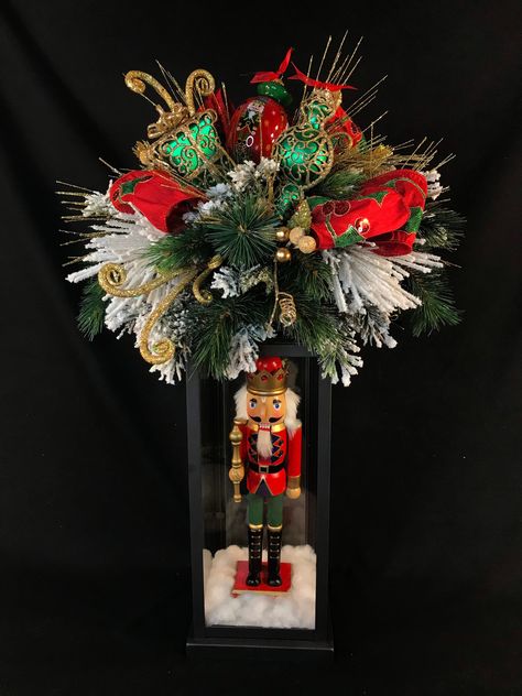 Elegant lighted Nutcracker Christmas lantern. This incredible design is a high end, unique, elegant Christmas nutcracker themed lighted lantern. The  base is a high quality black metal lantern.   On top of the lantern, I have layered snow covered greenery for a full, lush base.  Throughout the greenery, you will find coordinating glittered fillers and ornaments.  There is a florist bow and loops of a luxurious red and green Sequined Holly patterned ribbon.  In the center is a beautiful hand pain Christmas Lanterns Decorated Diy, Christmas Lanterns Decorated, Nutcracker Centerpiece, Christmas Boxes Decoration, Nutcracker Decorations, Christmas Centerpieces Cheap, Elegant Christmas Centerpieces, Elegant Christmas Party, Nutcracker Christmas Decorations