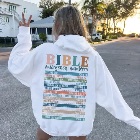 We produce the best quality designs for you like Bible Sayings Hoodie. Enjoy comfort and elegance.  Size: If you like a comfortable fit, you can increase your size selection by one size. If you're slim cut lover, please please make one size smaller. Wash Care Instruction: Please wash the product with cold water and turn inside out. Please do not dry at high temperature. Do not apply high pressure to the printing part while ironing on the product. If possible, iron the printing part on the baking Cute Christian Sweatshirts, Verses From Bible, Sweatshirt Sayings, Bible Emergency Numbers, Bible Sayings, Emergency Numbers, Christian Sweatshirts, Girly Christmas Gifts, Jesus Clothes