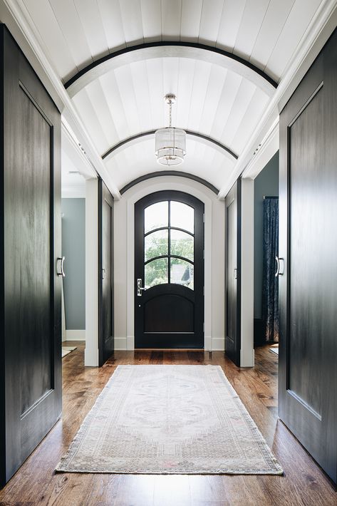 Gorgeous entryway with concealed barn doors underneath a white barrel vault paneled ceiling. | Amy Storm & Company | #entryway #archedceiling #entrywayideas #runner #barndoors Long Foyer, Barrel Vault, Barrel Vault Ceiling, Barrel Ceiling, Wood Parquet Flooring, Long Hallway, Entrance Foyer, Foyer Design, Entry Way