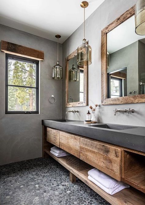 a rustic bathroom with concrete walls, a pebble floor, a rough wood vanity with a concrete countertop, pendant lamps and mirrors Drømme Bad, وابي سابي, Bathroom Concrete, Concrete Countertops Bathroom, Concrete Vanity, Countertops Concrete, Pebble Floor, Concrete Bathroom, Concrete Countertops Kitchen