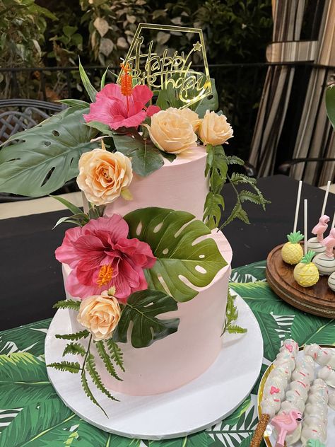 Light pink cake with tropical leaves and Hawaiian pink flowers Hawaiian Bridal Shower Cake, Tropical 70th Birthday, 50th Birthday Hawaiian Theme, 40th Birthday Tropical Theme, Hawaii Quinceanera Theme, Tropical Theme Quinceanera, Hawaiian Photo Booth Backdrops, Birthday Cake Tropical Theme, Hawaiian 60th Birthday Party