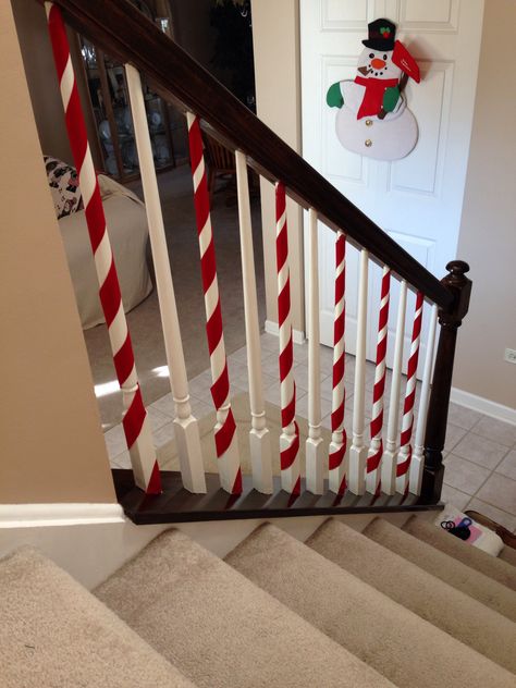 Candy cane railings! Super cute & easy to do! Our spindles are white all ready so I just wrapped red ribbon around them.  I taped the ribbon on the top & bottom. Christmas Wrapped Door, Christmas Decor On Stairs, Stairway Decor Ideas, Christmas Banister, Christmas Stairs, Stairway Decorating, Christmas Staircase, Christmas Themes Decorations, Indoor Christmas Decorations