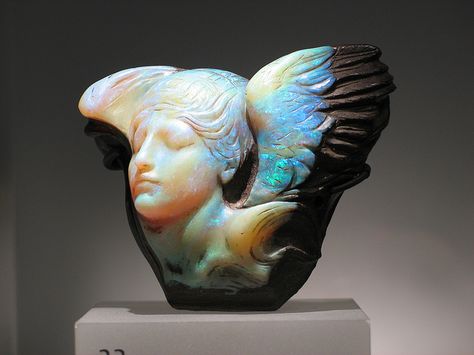 "Dream Cloud"  This piece is a Queensland, Australia boulder opal carving of a "winged female bust as personification of the dream" with the face turned well right, eyes closed. The entire carving weight is 1167 carats. Presently in the collection of the Royal Ontario Museum Bijoux Art Nouveau, Royal Ontario Museum, Crystal Power, Blue Angel, Art Antique, Rocks And Gems, Minerals And Gemstones, Gems And Minerals, 3d Modeling