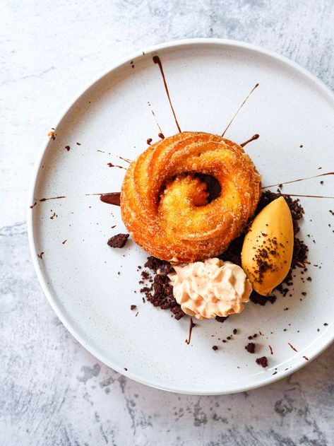 Churro Plated dessert There's just something about the crispy and doughy texture, the cinnamon sugar coating, and the way they're so perfect for dipping into chocolate that makes them irresistible. And now there's a new way to enjoy these delicious treats: as a plated dessert. Served with a “burnt” sugar ice cream, miso chocolate espuma, and a bitter chocolate sauce, it makes them even more irresistible. A super-easy plated dessert Dessert Recipes For Restaurants, Restaurant Plated Desserts, Ice Cream Plated Dessert, Simple Plated Desserts, Churros Plating Ideas, Churros Presentation Ideas, Easy Plated Desserts Ideas, Modern Dessert Plating, Easy Restaurant Desserts