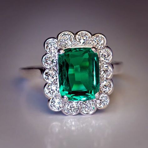 This vintage French platinum and 18K white gold engagement ring features a very rare untreated 2.31 ct Colombian emerald. The cushion cut emerald is extremely clean and full of life. The center stone is framed by chunky old European cut diamonds. Circa 1925.