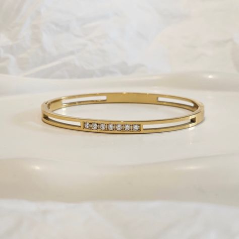 Our Diamond Station Bangle is the perfect stacking bangle. It features round set CZ crystals for a minimalist look. You can wear this minimalist bangle alone or stacked. This item is made from 316L stainless steel which is of the highest quality and waterproof as well as nickel free, lead free and cadmium free. We make our jewellery in small batches to reduce wastage. Our jewellery is designed with the modern Woman in mind, elegant, unique pieces with a classic touch. Our jewellery is great for Bangle Stacking, Minimalist Bangle, Gold Bangles For Women, Gold Jewellry, Womens Bangles, Accesories Jewelry, Bracelet Minimalist, Bangles Making, Gold Bangles Design