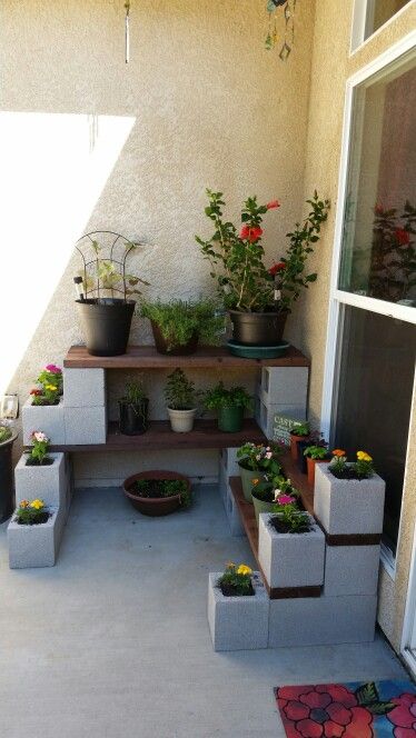 Cinder block and wood plant shelves. Cost less than $100. Apartment Patio Gardens, Cinder Block Garden, Diy Garden Patio, Cinder Blocks, Patio Garden Design, Garden Design Ideas, Patio Plants, Pallet Garden, Pallets Garden