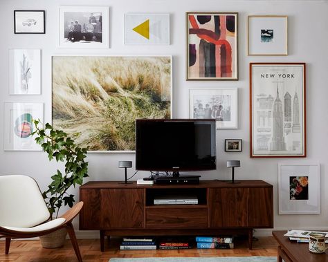 Ugh. A framed art cluster -- but I like it and need ideas for a massive wall behind my TV. I like that the large piece isn't centered above the TV. Wall Behind Tv, Tv Gallery Wall, Hiasan Dalaman Rumah, Reka Bentuk Dalaman, Deco Zen, Veronica Mars, Casa Vintage, Mobile Tv, Family Rooms