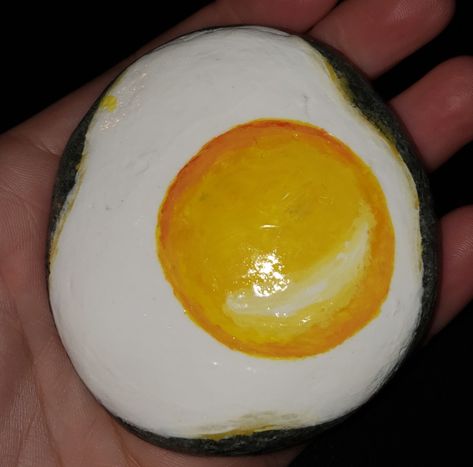 Fried egg painted rock Rock Painting Ideas Yellow, Food Painted Rocks Ideas, Banana Painted Rock, Rock Painting Food, Food Rock Painting Ideas, Rocks Painted Like Food, Egg Rock Painting, Food Painted Rocks, Egg Painted Rock