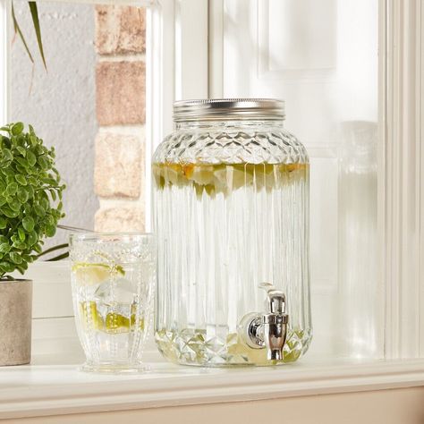 This vintage-style glass drinks dispenser jar is perfect for serving up your favourite beverages at parties, barbecues or any special occasion.  The clear glass adds a touch of elegance to any table setting, while the tap makes it easy for guests to help themselves. Crafted from high-quality glass, this jug is both durable and stylish.  The vintage design adds a touch of charm to your decor, making it the perfect addition to your home, bar or restaurant. Whether you're serving up cocktails, water or other refreshing drinks, this glass dispenser is sure to impress your guests. Technical Information: Clear glass drinks dispenser Made from high-quality glass Vintage style Features an easy-use tap to pour drinks  Convenient and easy to use Suitable for water, cocktails or any other cool bevera Glass Water Dispenser, Water Cocktails, Drinks Dispenser, Vintage Drinks, Glass Dispenser, Drink Dispenser, Water Jug, Water Dispenser, Refreshing Drinks