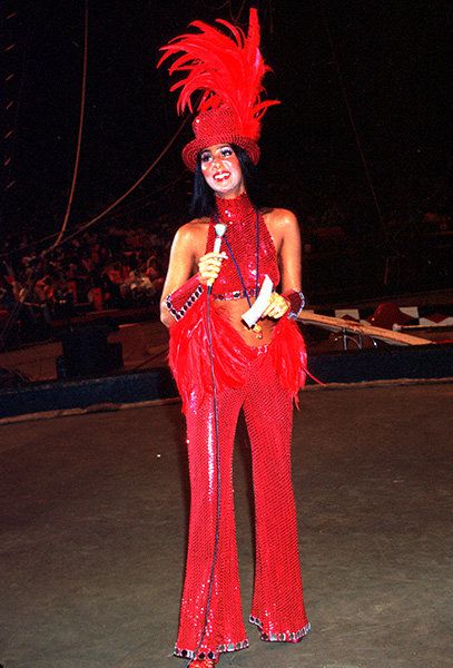 Cher in 1974 dressed as a ringmaster when opening for the Ringling Bros. Circus. This look screams camp style through the excess use of feathers and sequins, and the over-dramatic makeup and accessorizing. (Billboard) Cher Iconic Looks, Cher Halloween Costume, Cher 1970s, Cher Halloween, Iconic Cher, Cher Outfit, Cher Style, Cher Bob Mackie, Cher Looks