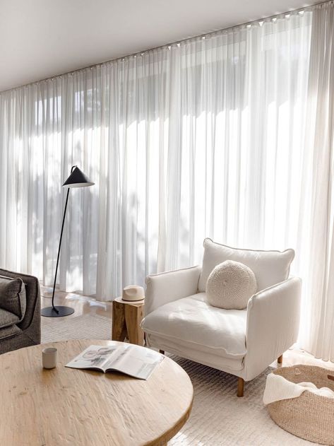 Neutral living room with a relaxed and coastal vibe. The white linen armchair, old elm wood coffee table, black floor lamp, sheer curtains and jute throw basket make this space layered in textures. Click to see more photos of this living room! Sheer Curtains Living Room, Linen Curtains Living Room, White Curtains Living Room, Sheers Curtains Living Room, Vibe White, Curtains Living Room Modern, Peacock Party, Beige Curtains, White Sheer Curtains