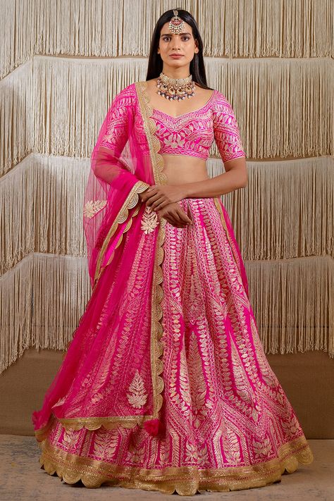 Featuring a dark pink lehenga in raw silk base with gota embroidery. It is paired with a matching blouse and a net dupatta.  FIT: Fitted at bust and waist. COMPOSITION: Raw silk, Net. CARE: Dry clean only. Luxury Pink Meenakari Choli, Luxury Raw Silk Choli With Gota Work, Luxury Gota Work Lehenga For Women, Luxury Pink Lehenga With Dori Work, Luxury Pink Traditional Wear With Tilla, Luxury Pink Traditional Wear With Traditional Patterns, Luxury Pink Bollywood Skirt, Cheap Pink Embroidered Traditional Wear, Luxury Cotton Silk Lehenga With Gota Work