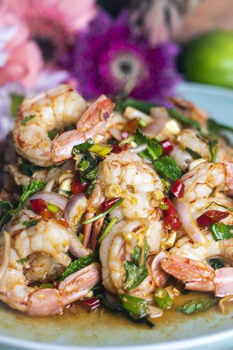 Need a tasty idea for a quick lunch? Try Pla Goong, a spicy Thai shrimp salad full of flavor. It has fresh herbs, big juicy shrimp, and spicy Thai chili peppers. The dressing is tangy and spicy too. Give your taste buds a treat with this yummy salad you'll want to eat again and again! #plagoongrecipe #plagoongingredients #plagoongsaladrecipe #thaishrimpsalad #spicythaishrimpsalad #prawnsaladthai #plagoongsalad Chinese Salads, Spicy Thai Shrimp, Thai Shrimp Salad, Thai Chili Peppers, Thai Appetizer, Thai Shrimp, Prawn Salad, Food Seafood, Thai Salads