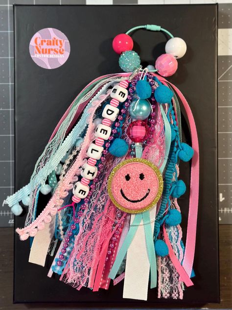 This preppy tassel makes the perfect accessory for any beach bag, pool bag, dancer bag, cheer bag, backpack, bogg bag, or your everyday bag! Preppy girls love this tassel   You can personalize these tassels with your name & color choices. For large group orders, please message us. If we don't get a message with additional colors, we will automatically pair your primary color with white. We use various kinds of ribbon, trim, beads, yarn, and lace to make our adorable tassels. Please be specific i Ribbon Bag Tutorial, Beaded Tassels Tutorial, Bag Tassel Diy, Bogg Bag Tassel, Crafts Teens, Preppy Smiley Face, Cheer Team Gift, Bogg Bag Charms, Fabric Tassels